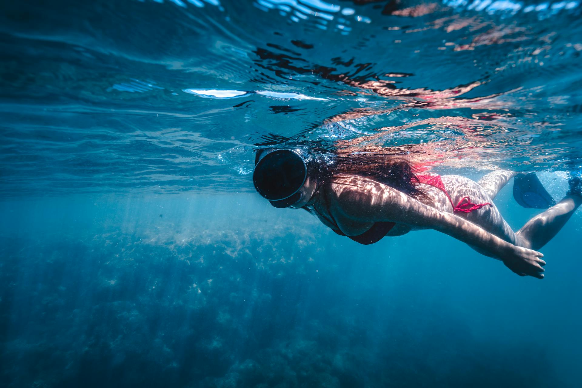  a woman in a snorkelling mask swimming underwater