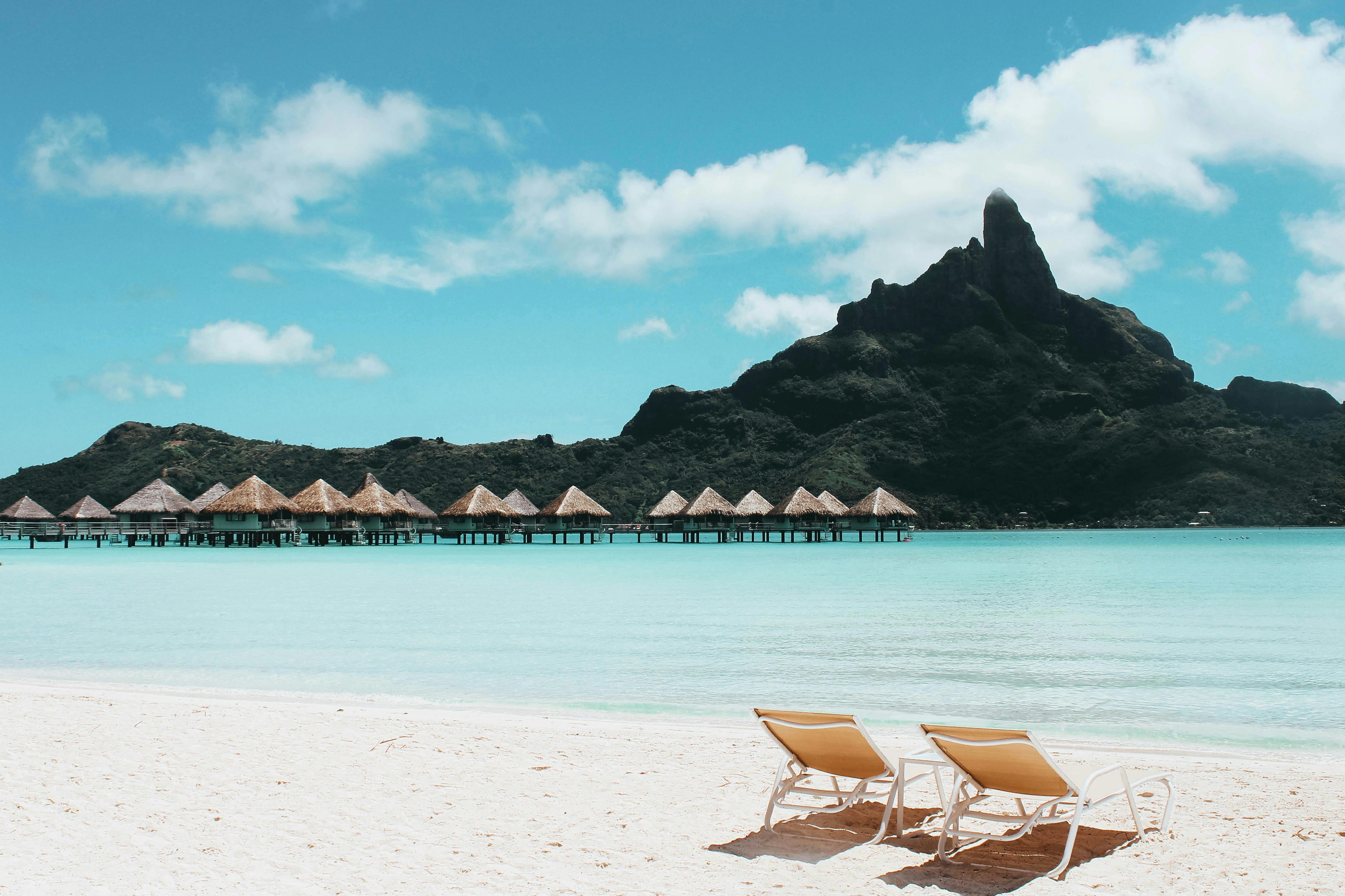 an island with cottages and beach chairs on the sand