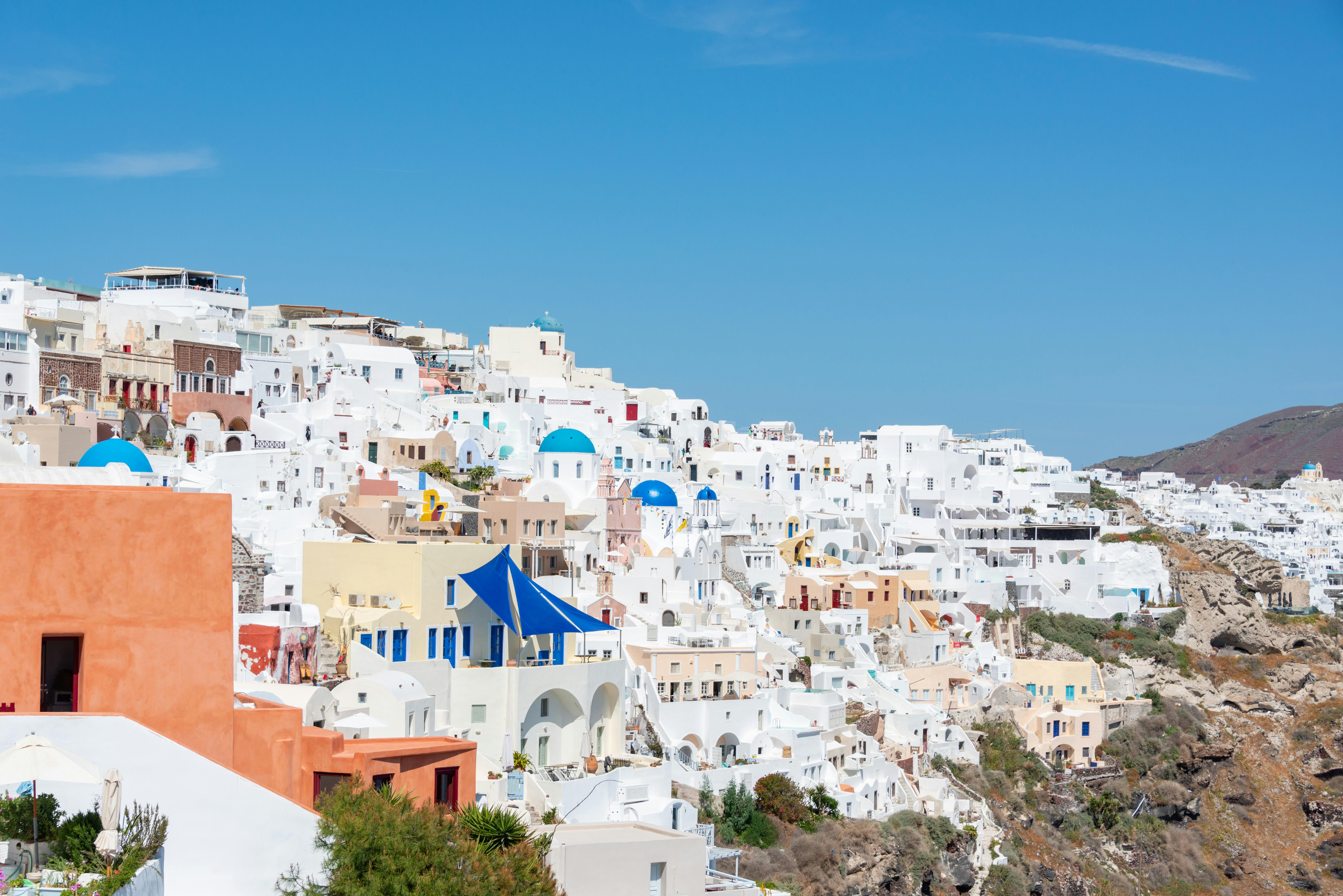 Whitewashed houses and blue-domed churches cascade down Santorini’s cliffs