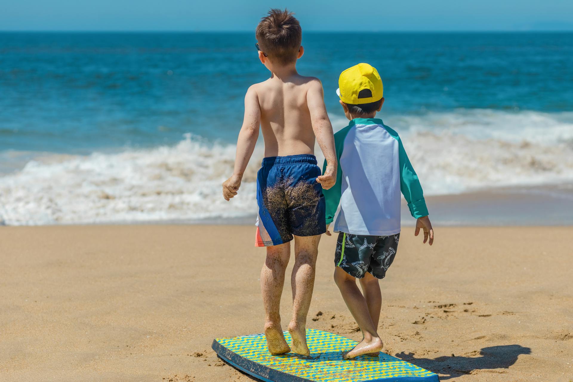 Two kids standing on a beach