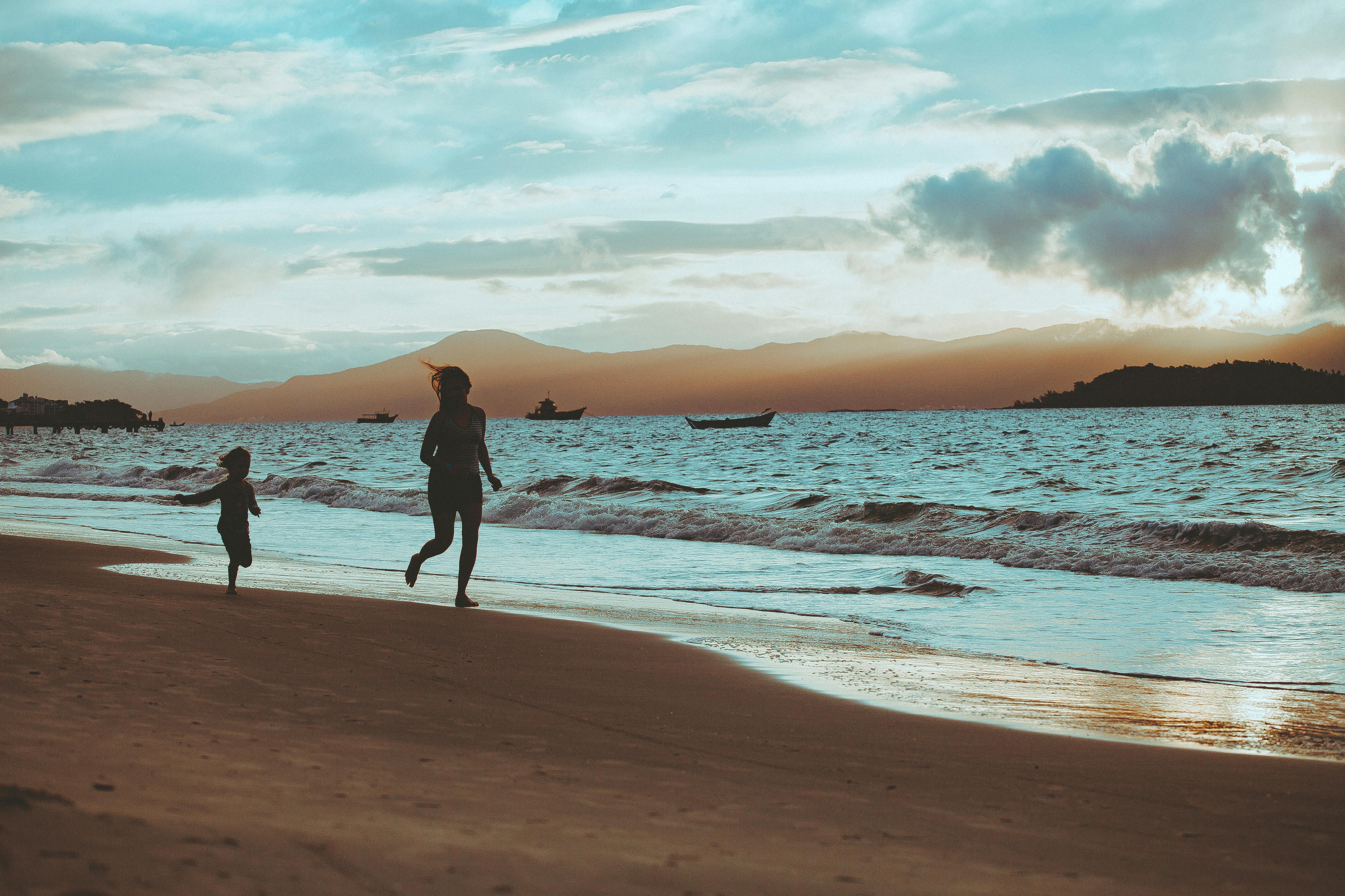 A joyful family runs along a sandy beach in Fiji