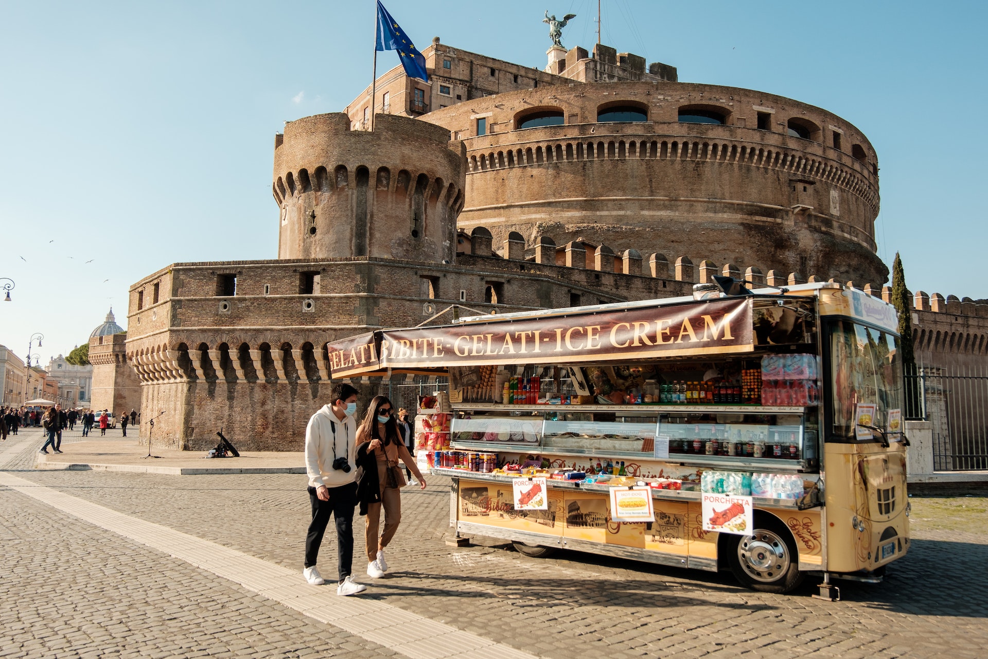 people passing by a street food truck in Italy