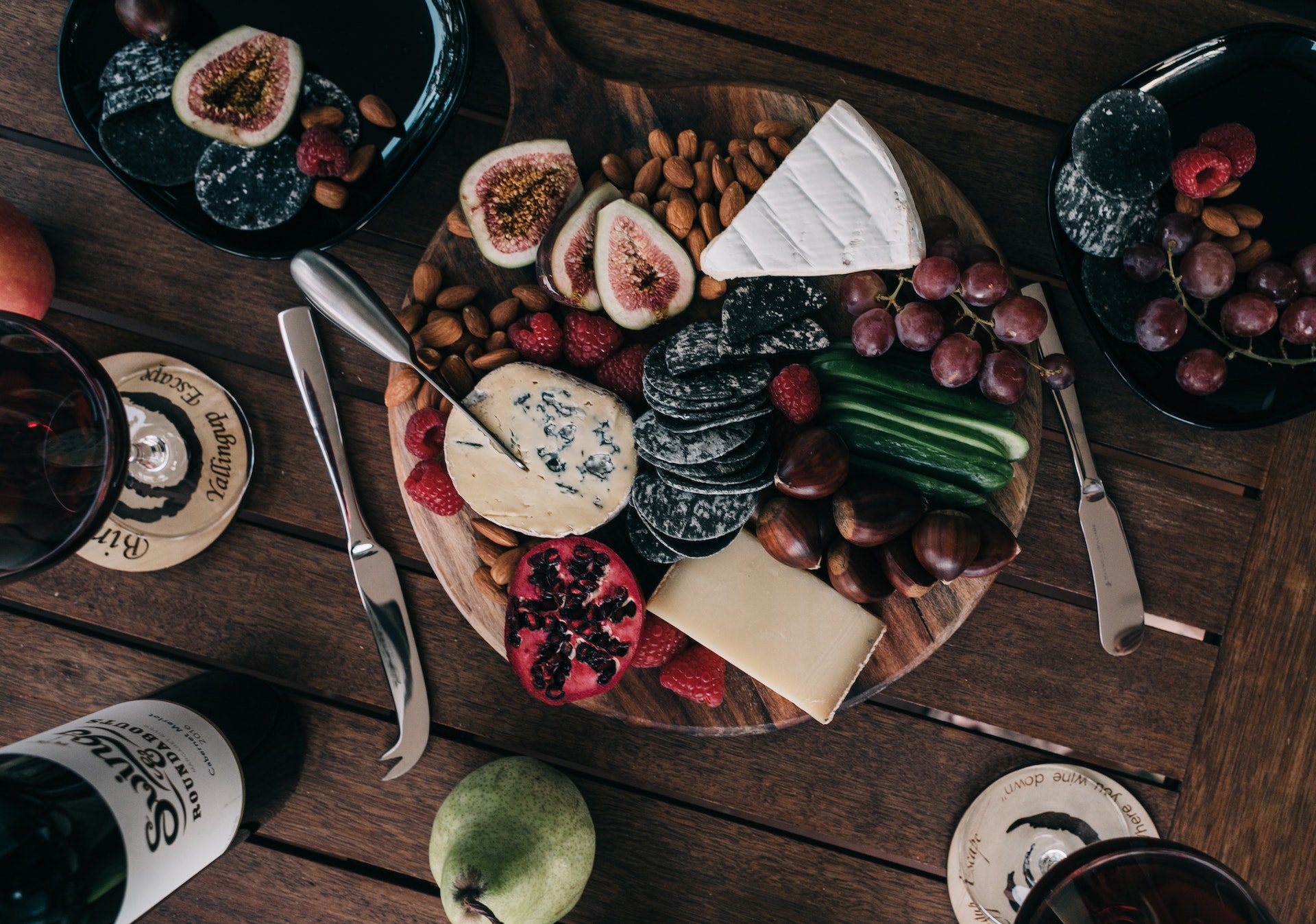 Wooden tray with cheese, biscuits, and wine