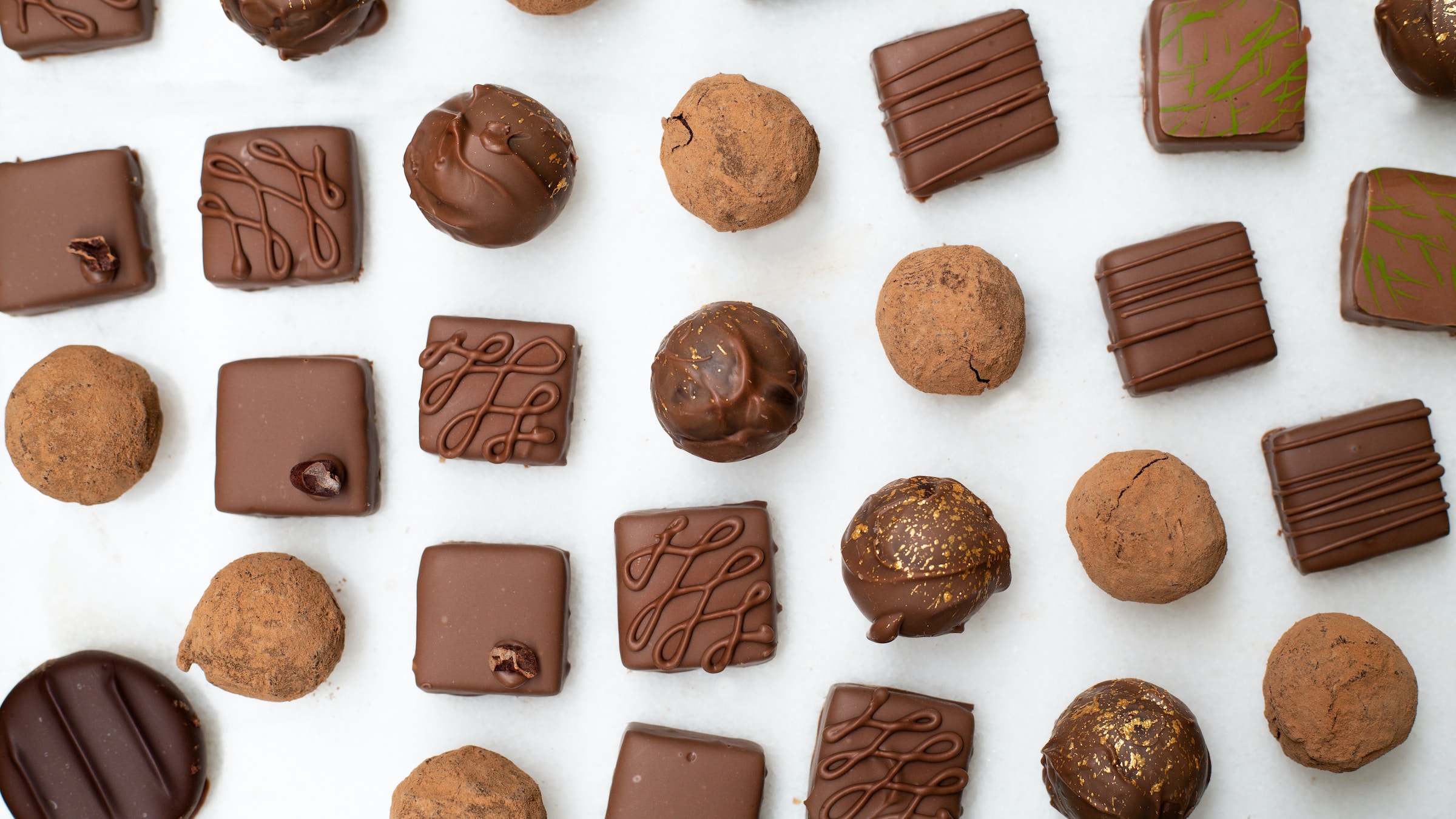 Small pieces of chocolate laid out on a white surface