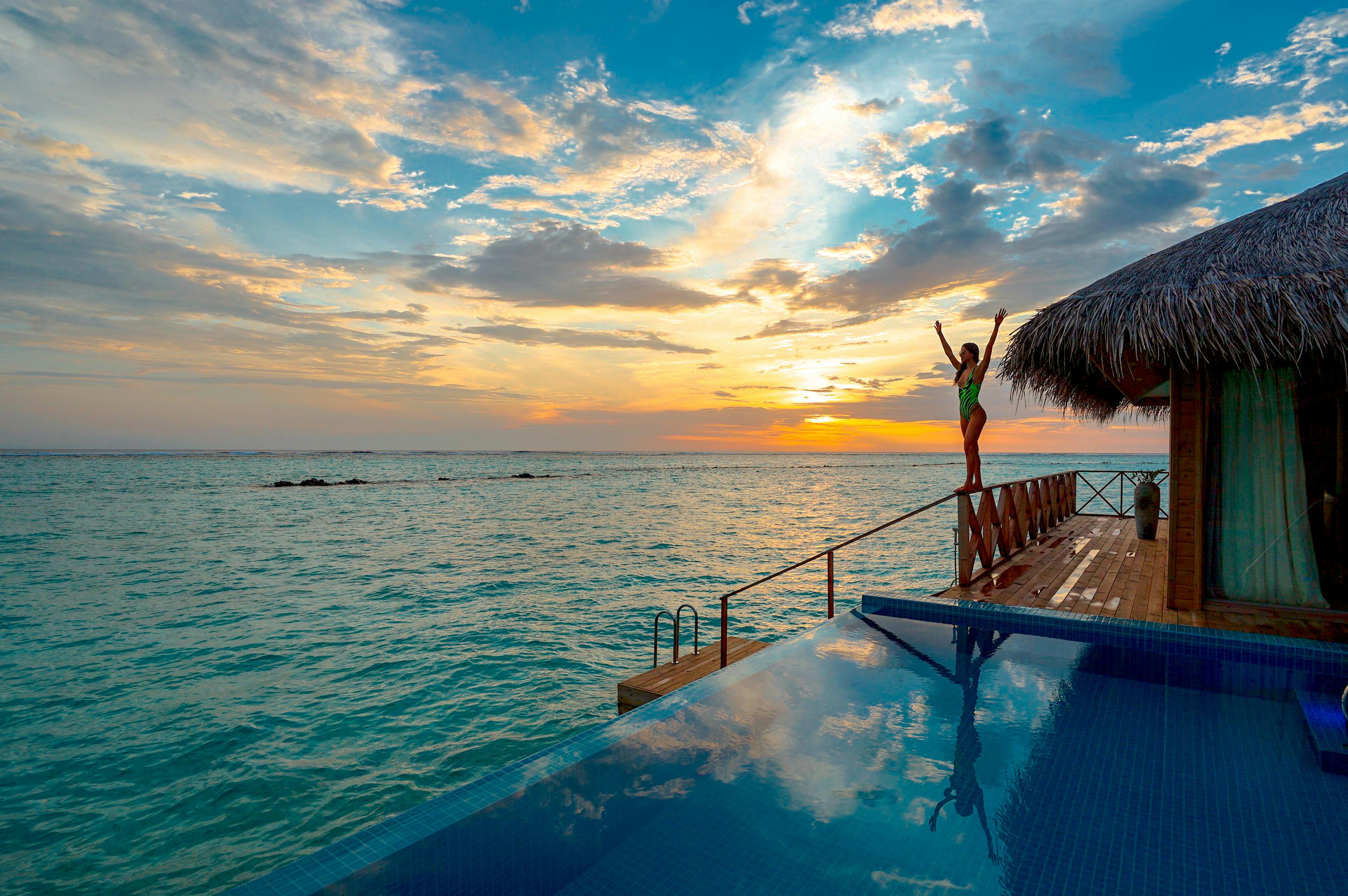 An infinity pool seamlessly blending into the turquoise sea captures the essence of luxury in the Maldives