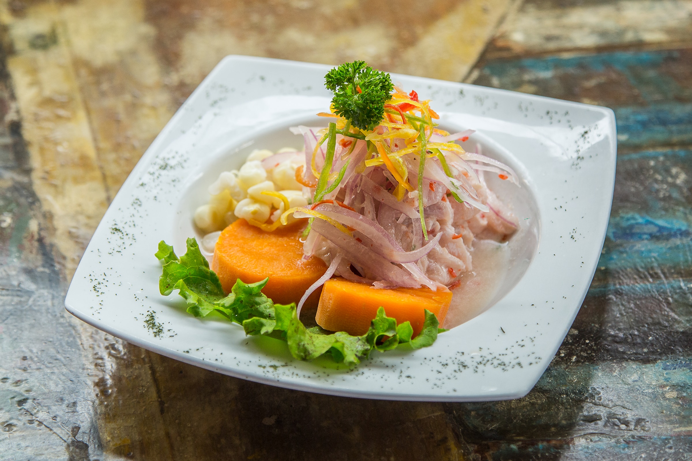 a plate full of raw fish salad on a table