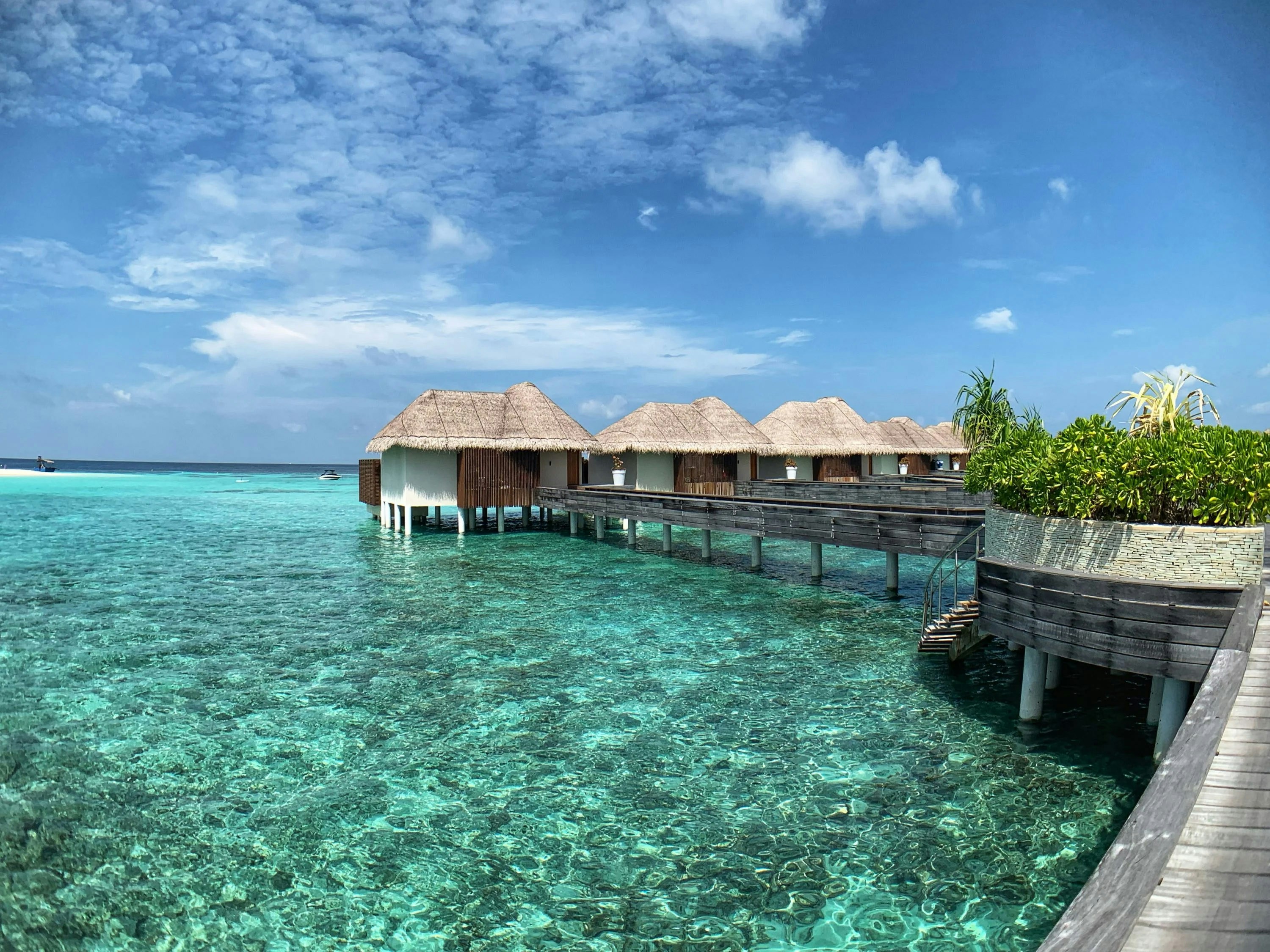 White and brown overwater bungalows overlooking a blue-green lagoon.